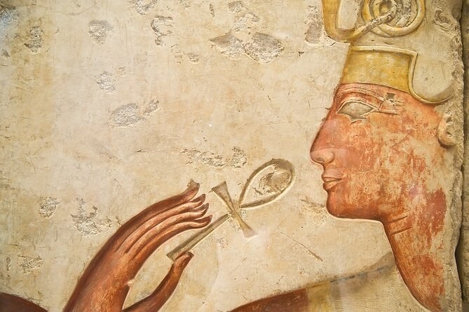 A painted Egyptian relief of a pharaoh holding an ankh